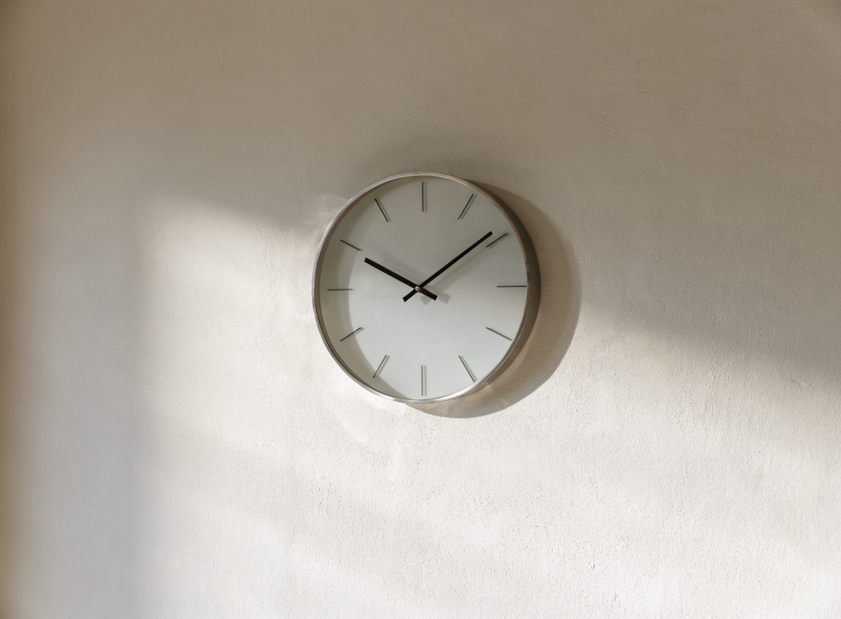 Horloge murale design à cadre métallique fin sur un mur en plâtre Image