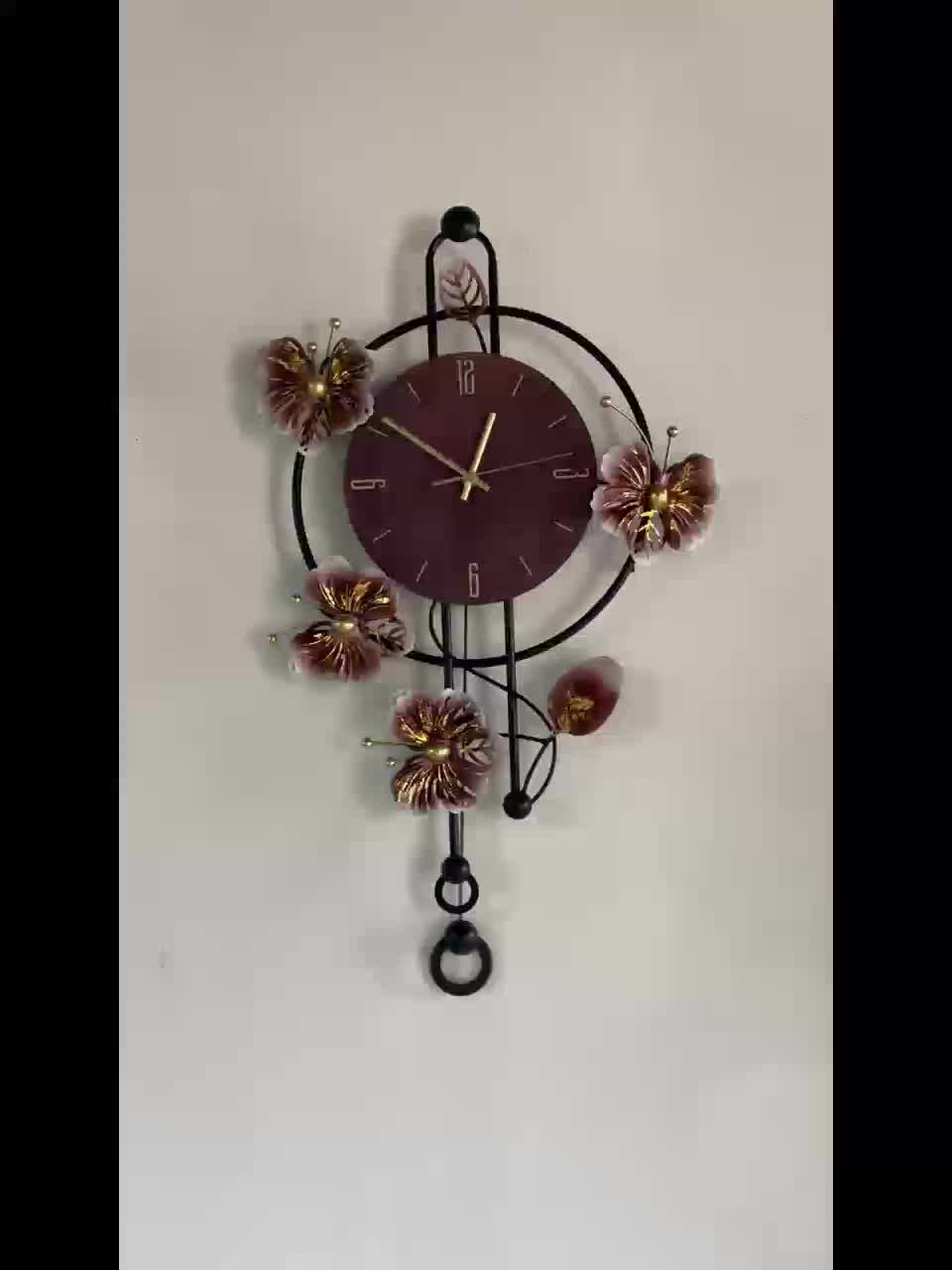 Horloge murale papillons en fer noir et balancier suspendu